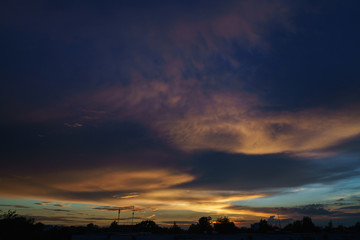 sunset clouds and colored sky over town