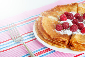 Raspberry pancakes served with sugar powder