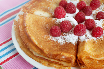 Raspberry pancakes served with sugar powder