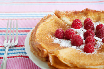 Raspberry pancakes served with sugar powder