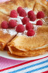 Raspberry pancakes served with sugar powder