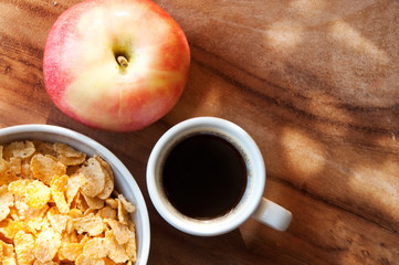 Breakfast with coffee, cereals and an apples on wooden table 