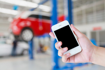 woman hand hold touch screen mobile smart phone with car garage