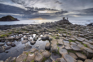 NORTHERN IRELAND; Basalt formation of Giants Causeway at sunset under dramatic sky