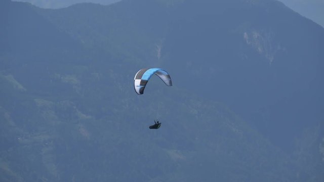 Paraglider in front of the slope in the mountains