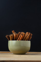 Cinnamon Sticks in Green Bowl with Chalkboard Background