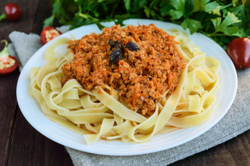 Pasta tagliatelle with meat sauce bolognese on a white plate. The traditional view of food.