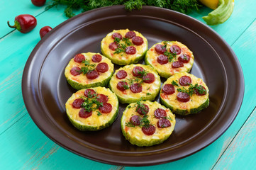 Small zucchini pizza on the circles with pepperoni and mozzarella. Close up