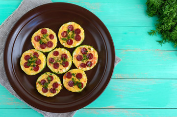 Small zucchini pizza on the circles with pepperoni and mozzarella. The top view