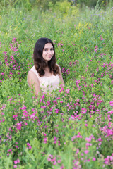 girl sitting on meadow with  flowers