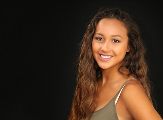 Portrait of a beautiful smiling young woman with long hair and a suntan