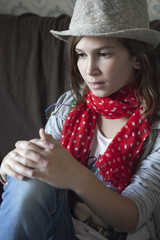 Portrait of beautiful girl in jeans wearing hat and red scarf si