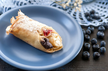 closeup pancake with berries on blue flat on dark wooden backgro