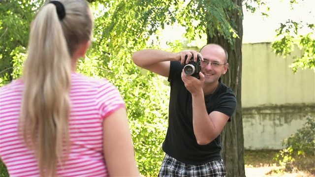 Cute photographer photographing woman in Park