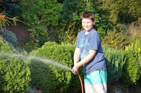 Kinder im Sommer spritzen mit Wasser - Gartenschlauch