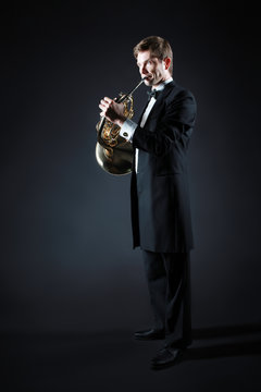 French horn player with music instrument