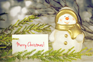 Merry Christmas card. Christmas card with snowman figurine and natural decoration