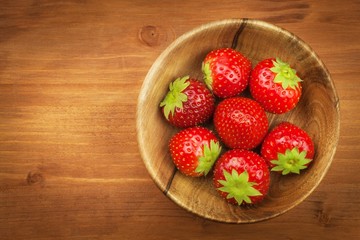 Strawberry on a wooden background. Strawberries in bowl.
