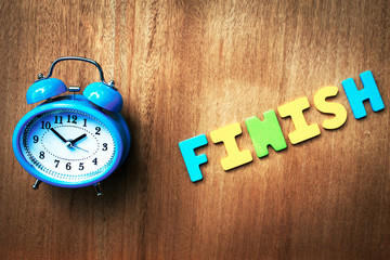 clock and finish word writen on wooden background