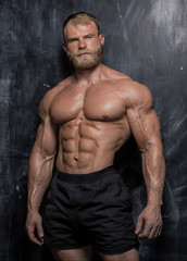 Fototapeta na wymiar Muscular bodybuilder guy over darck background