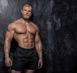 Fototapeta na wymiar Muscular bodybuilder guy over darck background