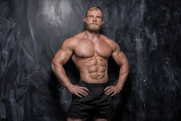 Muscular bodybuilder guy over darck background