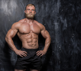 Muscular bodybuilder guy over darck background