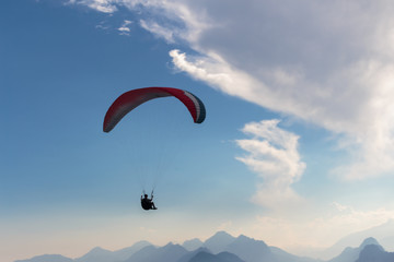 Parachute and human silhouette. Blue sky and adventure.
