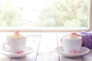 Little Girls Hands Holding Hot Chocolate on White Table Looking Out Window with Copy Space
