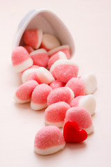 Pink jellies or marshmallows with sugar on table