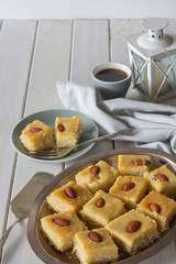 Homemade Basbousa with Coffee on White Wooden Table Vertical with Copy Space