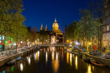 Fototapeta na wymiar St.Nicolas church and canals at night in Amsterdam, Netherlands.