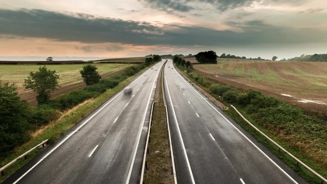 Time Lapse of fast speeding vehicles on rural motorway M54 in UK. Smooth transition from late eveing throught sunset and twilight.