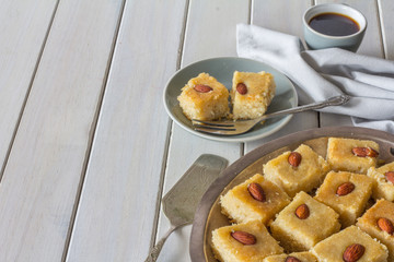 Homemade Basbousa with Coffee on White Wooden Table Horizontal with Copy Space