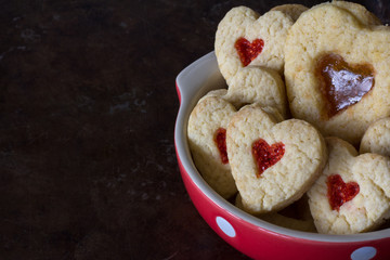 Bowl of Heart Cookies with Different Fillings on a Dark Tray with Copy Space Horizontal