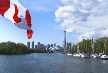 Beautiful Canada flag is waving front of famous Toronto City view