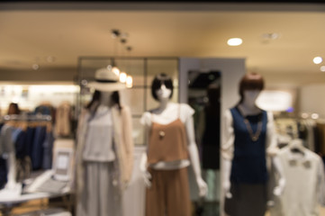 De focused/Blur image of boutique window with dressed mannequins. Boutique display window with mannequins in fashionable dresses. Toned image.