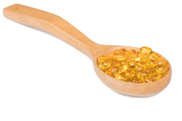 Fish oil capsules in a spoon isolated on white background