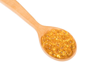 Fish oil capsules in a spoon isolated on white background