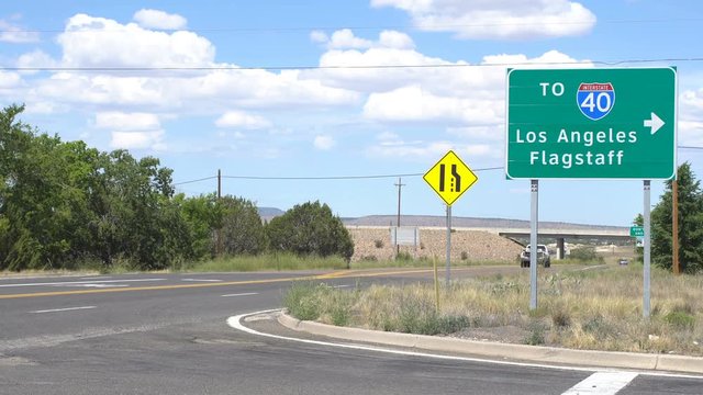 Tow truck and a pickup truck on historic route 66 near an exit to Los Angeles and Flagstaff via Interstate 40