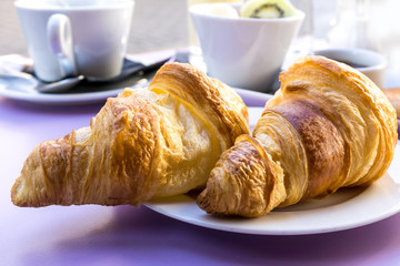 Breakfast with coffee and croissants on table