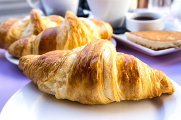 Breakfast with coffee and croissants on table