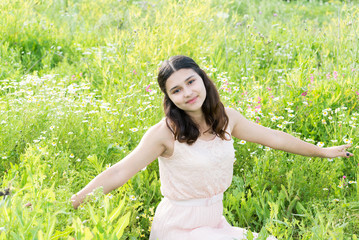 Naklejka na ściany i meble Teenage girl resting on flower meadow