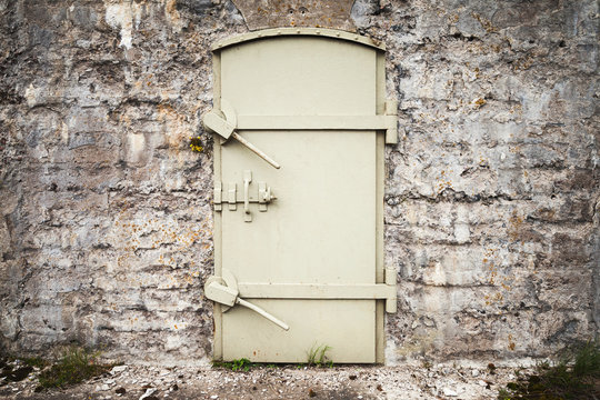Locked massive metal door in old wall