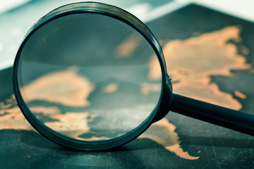 Magnifying lens on grunge world map