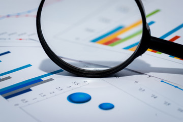 Business Analysis Image - magnifying glass on graphs and spreadsheet