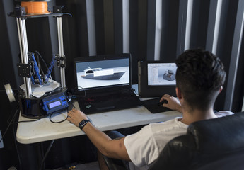 Back view of designer modelling ship to print it on 3D printer