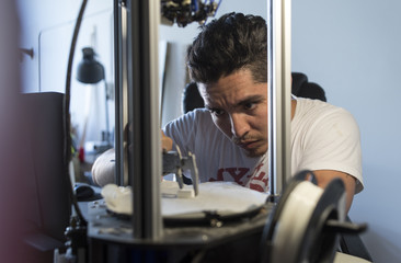 Male designer using 3D printer in design studio