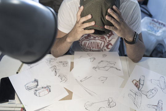 Puzzled designer at table with sketches