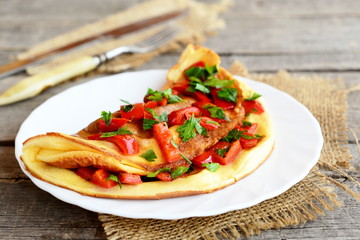Vegetable egg omelette on a plate. Vegetarian omelet with fried red pepper, fresh parsley and spices. Fork, knife on a burlap and on old wood background. Breakfast recipe - obrazy, fototapety, plakaty